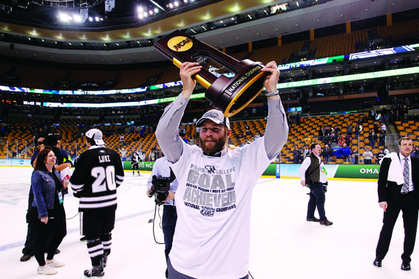 Drew Brown ’16 hoists the NCAA trophy during the on-ice celebration.