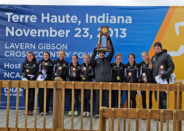 Head Coach Ray Treacy ’82 proudly raises the NCAA Championship trophy during the awards ceremony in Terre Haute, Ind. He is flanked by team members, from left, Bryanna Allison ’17, Sarah Mary Collins ’16, Erin Murphy ’14, Grace Thek ’14, Emily Sisson ’14, Laura Nagel ’14, Catarina Rocha ’17, Molly Keating ’16, and Assistant Coach Kevin Myles. (Photo by Tim O'Dowd)