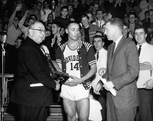Lenny Wilkens ’60 accepts the Most Valuable Player trophy after PC won its own holiday tournament during the 1959-60 season. Rev. Aloysius B. Begley, O.P. ’31, athletic director, presents the award as Head Coach Joe Mullaney looks on.