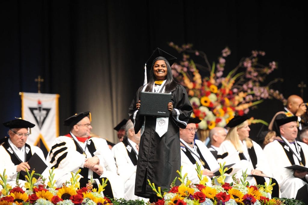 A proud graduate clutches her degree.