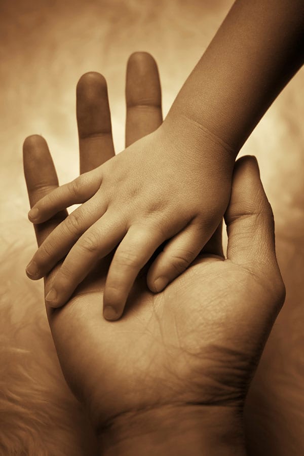 child's hand in adult hand
