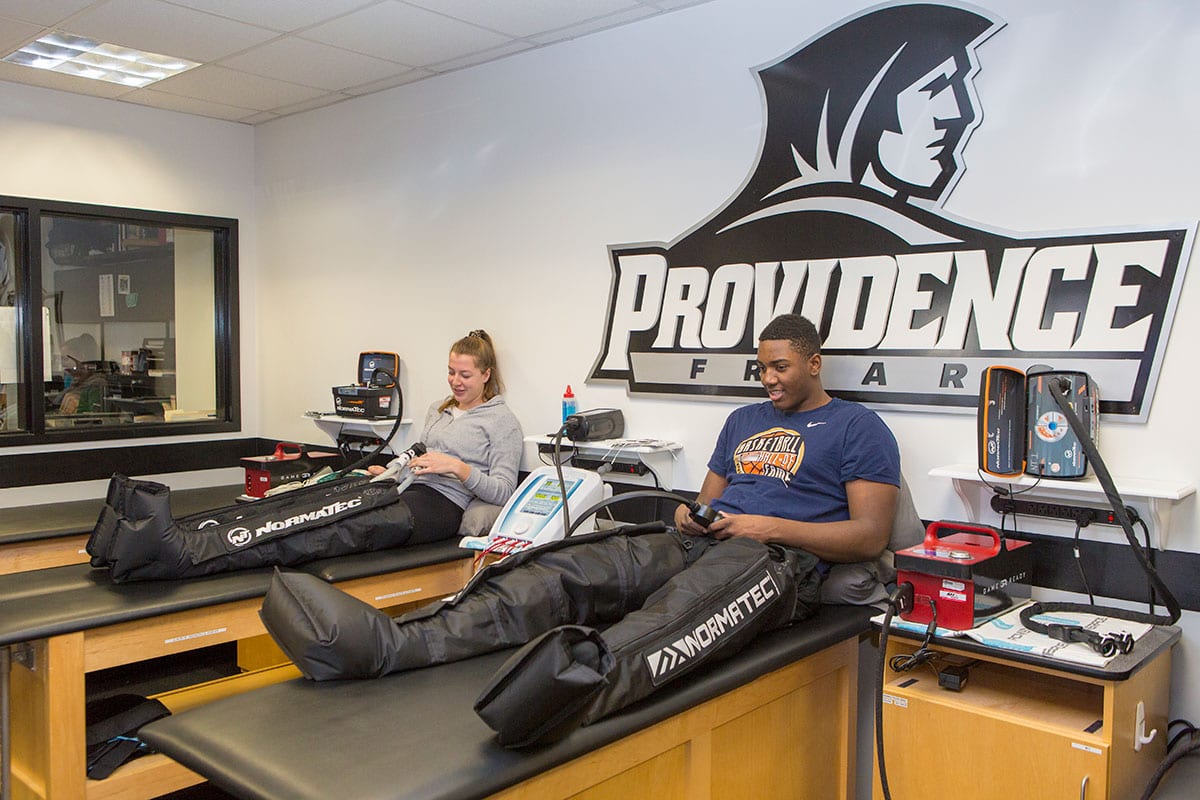 Floor Rozemeijer ’20 of the field hockey team, left, and Kalif Young ’20 of the men’s basketball team share a laugh as they get treat-ment through the new NormaTec compression-boot systems. 