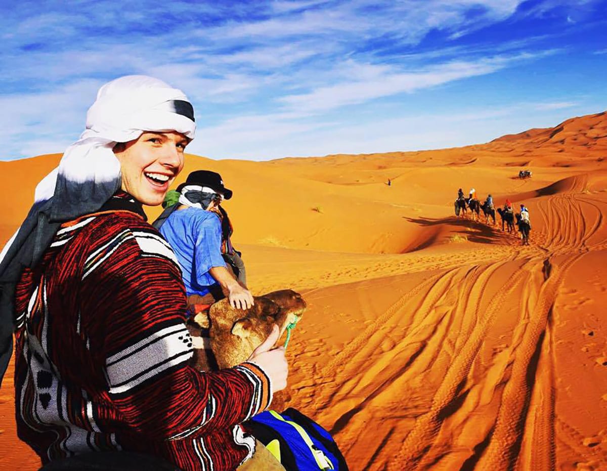 From left, Connor Kinkead '17 and Conor Gibbons '17 join a group for a camel ride in a Moroccan desert. 