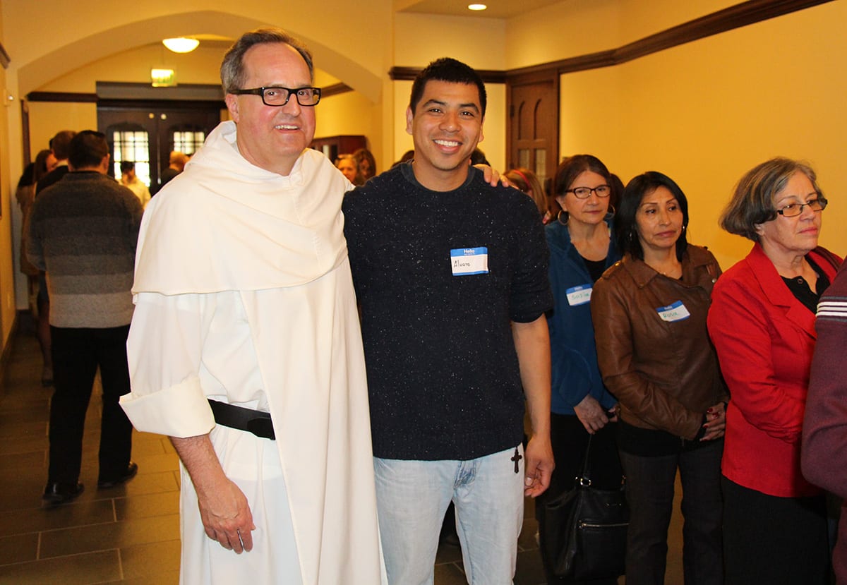 Rev. David T. Orique, O.P. greets one of the Latino Symposium guests during a break in the programming. 
