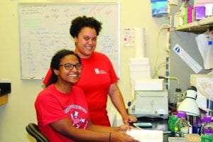 Postdoctoral research associate Cara Pina, rear, works with Nicole De La Rosa ’18 in the lab of Dr. Brett Pellock, associate professor of biology.