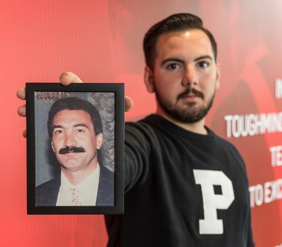 Joseph Padavano '17 holds a photo of his father, Louis, who died in 2011. Padavano and Everett Gabriel '71 & '77G both lost their fathers while in high school.