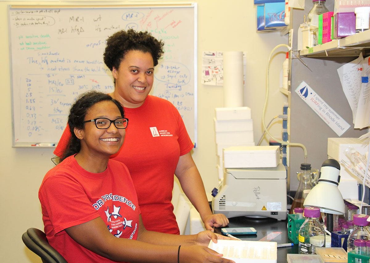 Dr. Cara Pina, rear, works in the biology lab with Nicole De La Rosa ’18. 