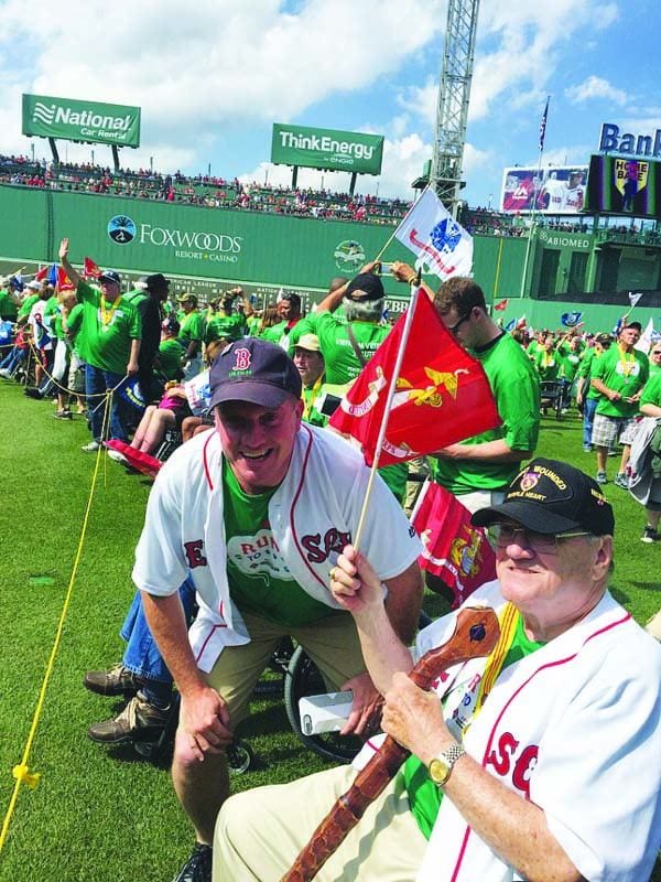 Daniel M. Walsh, III '64, right, takes in the scene on the field at Fenway Park with his son, Bennett W. Walsh '92. 