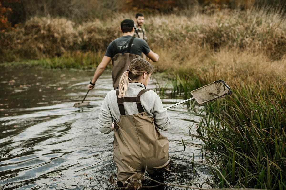 Wildlife Biology and Conservation students Sarah Mealey '17 and Peter Sanders '17 follow their professor, Dr. Jonathan Richardson, through a pond in Warren.