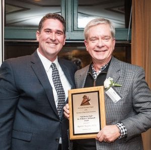 McGwin, right, accepts the Dr. William A. McDonnell Award from Bernard A. Manchester '04 of the Greater Providence Chapter of the NAA, the Mal Brown Club, in February 2018. The award is given to individuals who have given unselfishly of themselves to further the cause of PC.