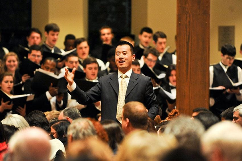 Dr. T.J. Harper conducting combined choirs during Lessons & Carols in St. Dominic Chapel.