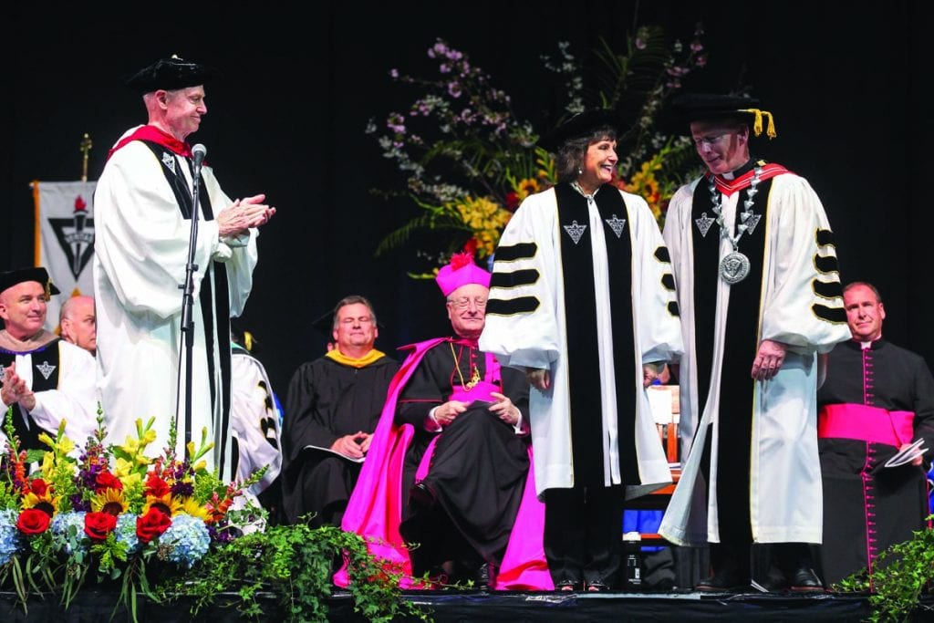 Lisa M. (Thibault) Schenck ’83 & ’18Hon. shares a smile with College President Rev. Brian J. Shanley, O.P. ’80 while being awarded an honorary degree at commencement in May. At left is Very Rev. Kenneth R. Letoile, O.P. ’70, chairman of the Providence College Corporation and prior provincial of the Dominican Province of St. Joseph.