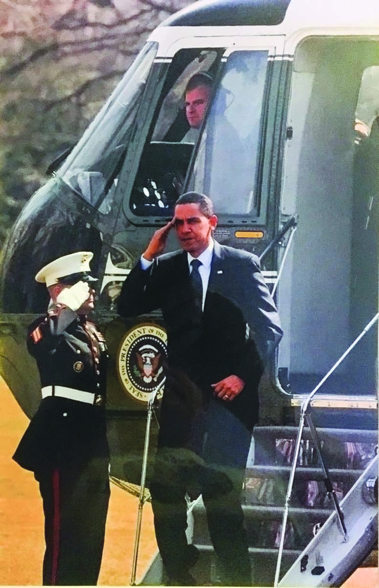President Barack Obama salutes as Lt. Col. Kevin G. Hunter '99 watches from the cockpit of Marine One.