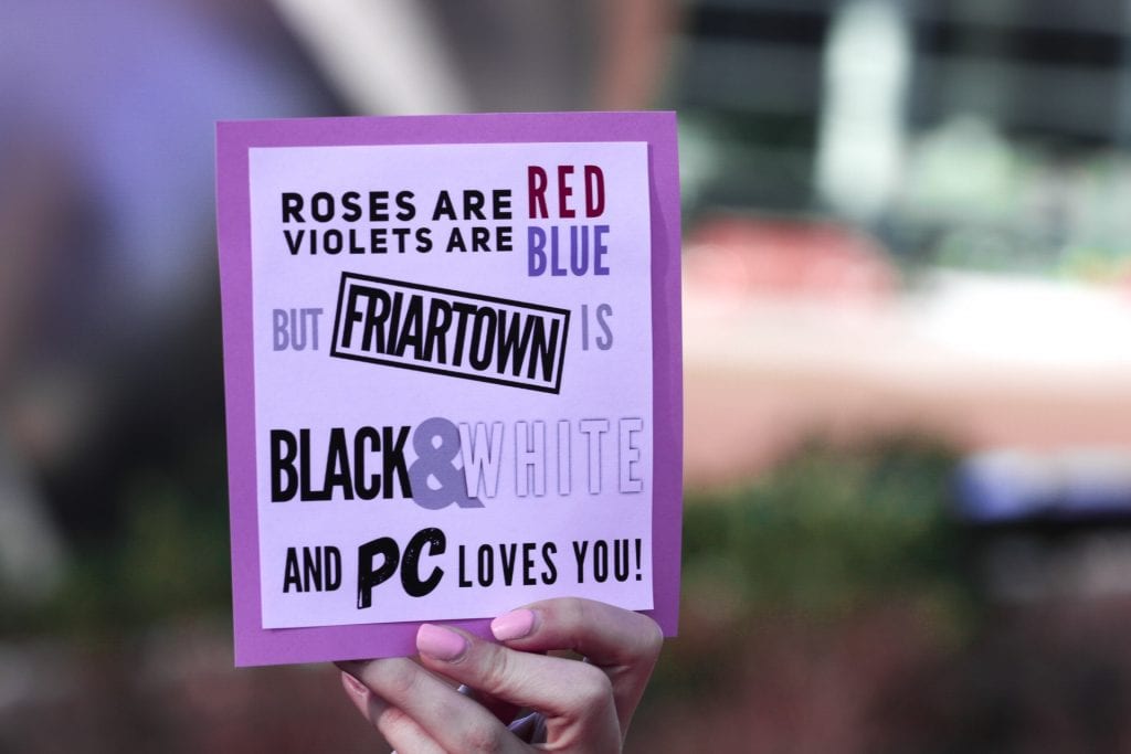 A hand holds a valentine that reads "Roses are red, violets are blue, but Friartown is black & white and PC loves you."