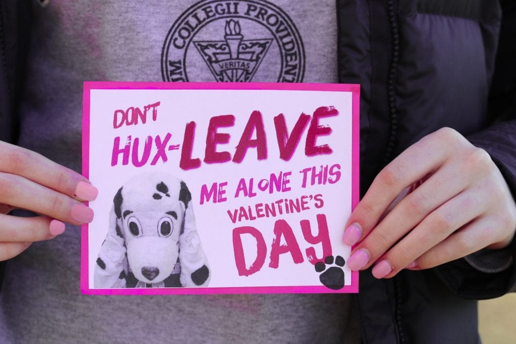 A person wearing a Providence College shirt holds a valentine that reads "Don't Hux-Leave me alone this Valentine's Day."