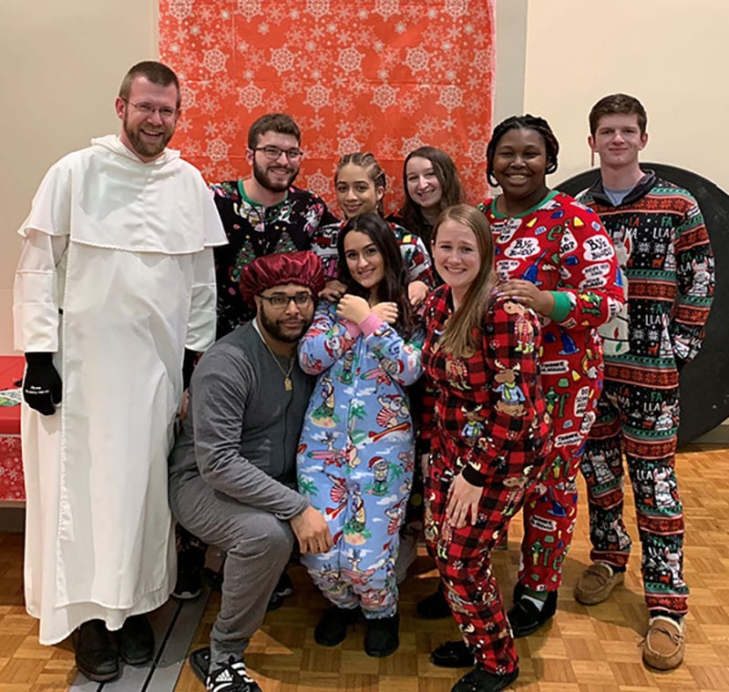 Rev. Vincent Ferrer Bagan, O.P., visiting faculty member in music and a residence hall chaplain, enjoys a Christmas celebration with residence life staff members from Bedford and Davis halls at the end of the fall semester. 