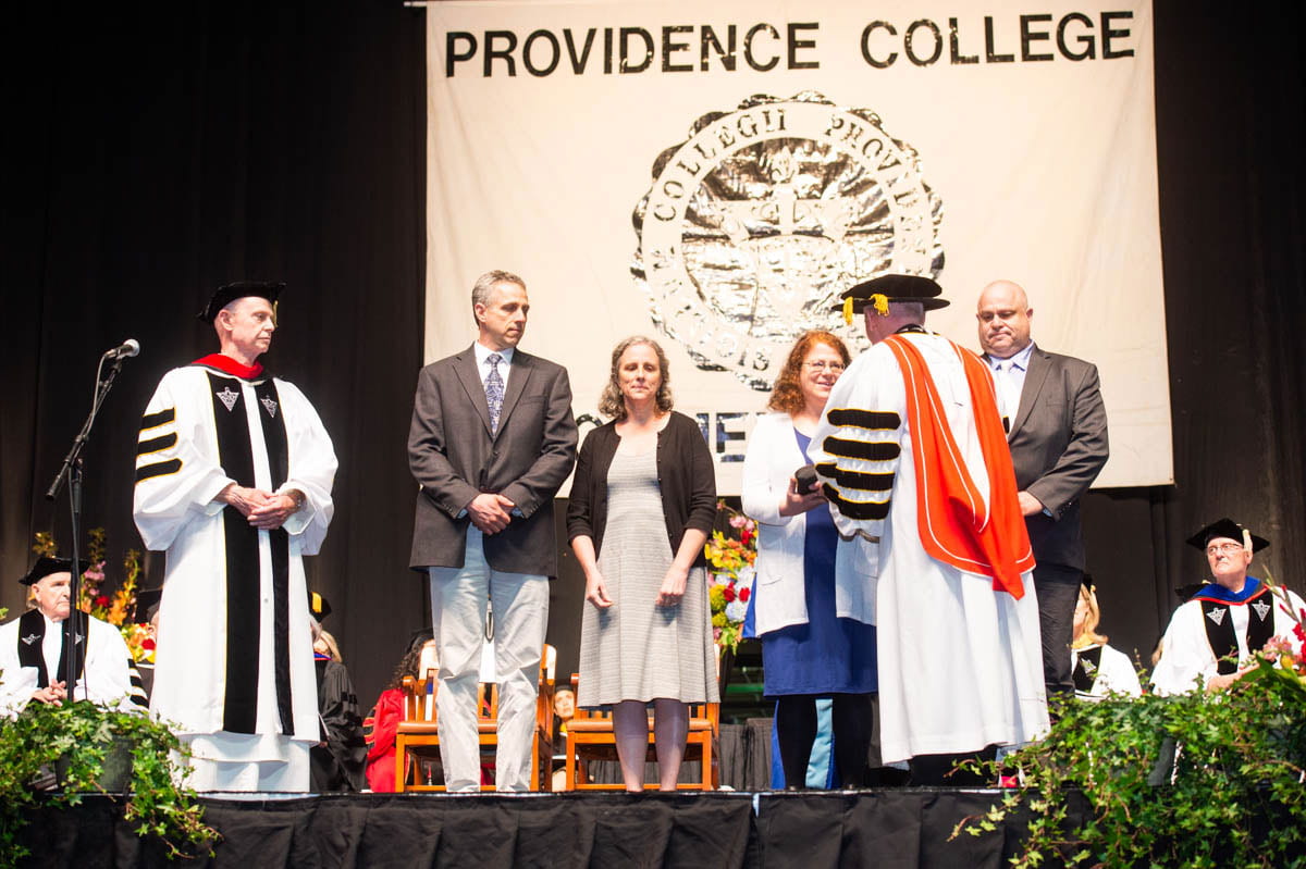 The children of the late Dr. Stephen J. Mecca ’64 & ’66G accept their father’s honorary Doctor of Science degree posthumously. College President Rev. Brian J. Shanley, O.P. ’80 presents the symbolic hood to Laura E. Ray. Other siblings are, from left, Stephen D. Mecca ’88, Lisa K. Sallee ’88, and Michael R. Mecca ’90 & ’92G. At left is Very Rev. Kenneth R. Letoile, O.P. '70, chair of the Providence College Corporation.