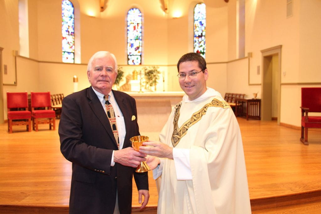 John G. Hussey ’68, left, presents his brother’s chalice to Rev. Peter Martyr Yungwirth, O.P., College chaplain.