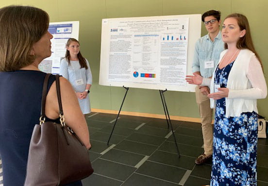 Madison Palmer '21 answers questions at the SURF Conference at URI while Emily Wall '21 and Cameron Mimoso '20 look on.