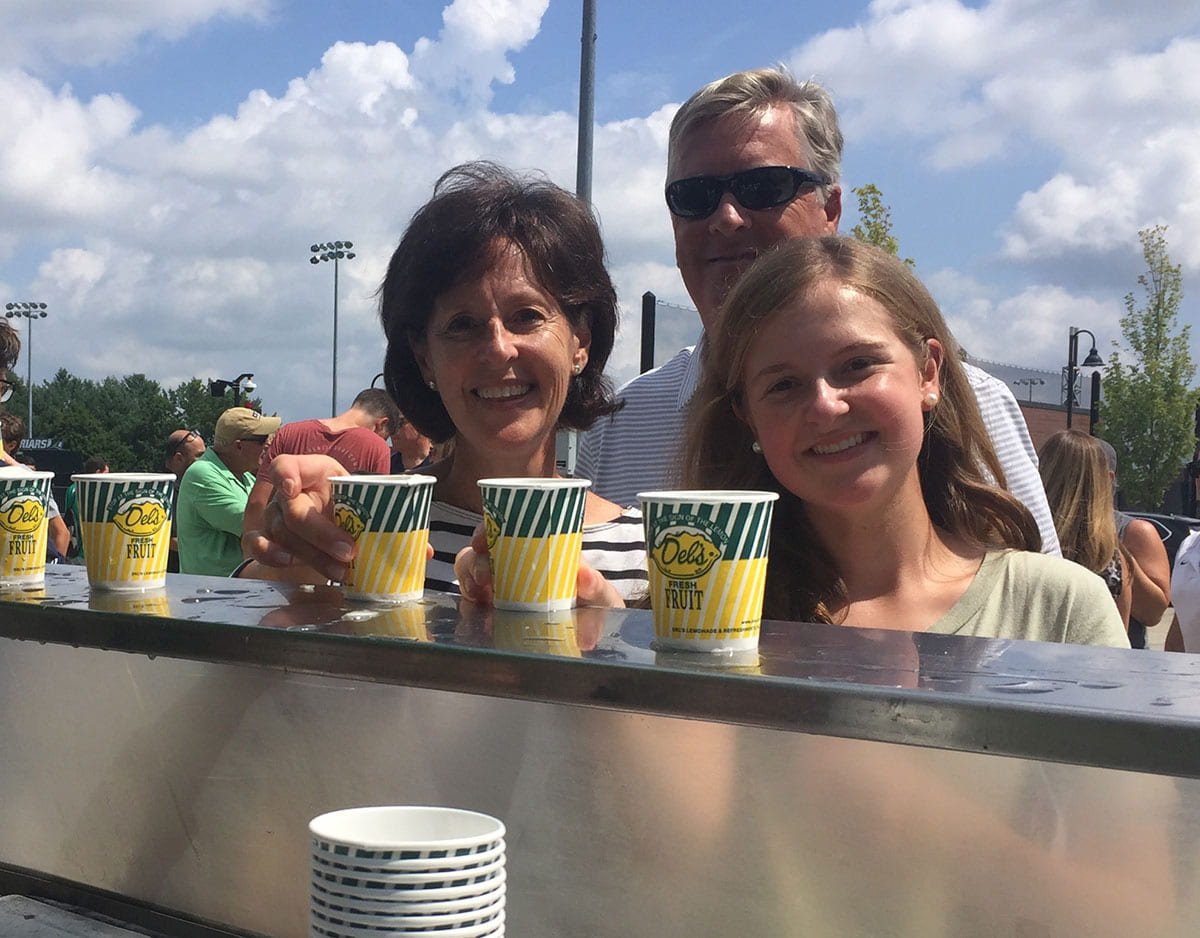 Caroline Lewers '23 and her parents pause for some Del's frozen lemonade at a cart manned by the Student Alumni Association. They are from Wayne, Pa.