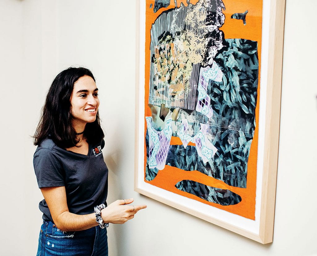 Micaela "Kit" Freeman '20 stands next to a mixed-media work by Will Hutnick '07, a New York artist. Freeman worked for the PC Galleries in the summer of 2019 through an internship sponsored by Eric "Pete" Peterson '86 and Theresa Peterson '86.