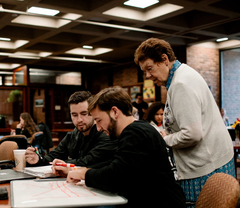 Sister Carolyn Sullivan, O.P. ’02G checks in with students studying in the Office of Academic Services.