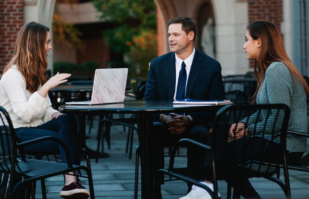 His students say that Dr. Edward E. Andrews is as accessible outside the classroom as in it. Here he meets with students on the patio outside the Ruane Center for the Humanities.