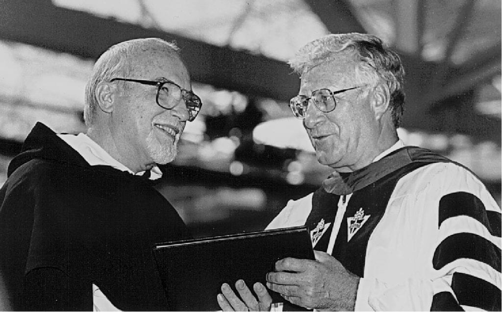 Father McAlister, left, accepts his citation as professor emeritus from College President Rev. Philip A. Smith, O.P. '63 at Academic Convocation in 1997.