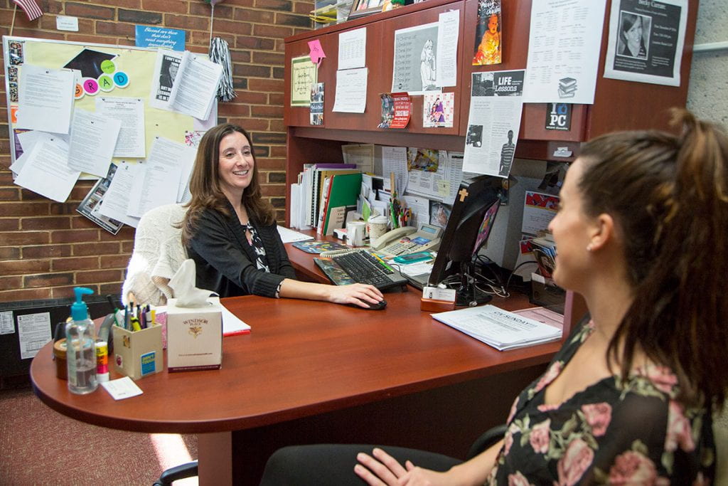 Jennifer Rivera '06 & '13G at work in her office in Phillips Memorial Library in 2016.