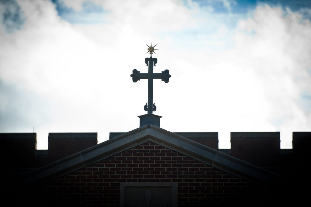 Silhouette of a cross, against a cloudy sky