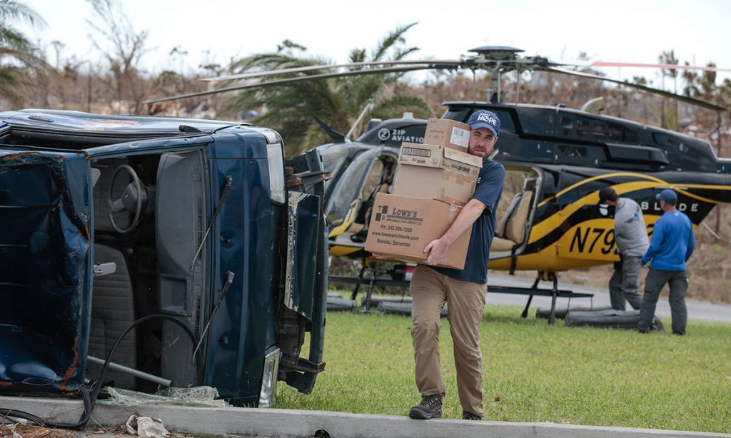 Tom Cotter '10 carries a stack of supplies in the Bahamas after Hurricane Dorian in the summer of 2019.