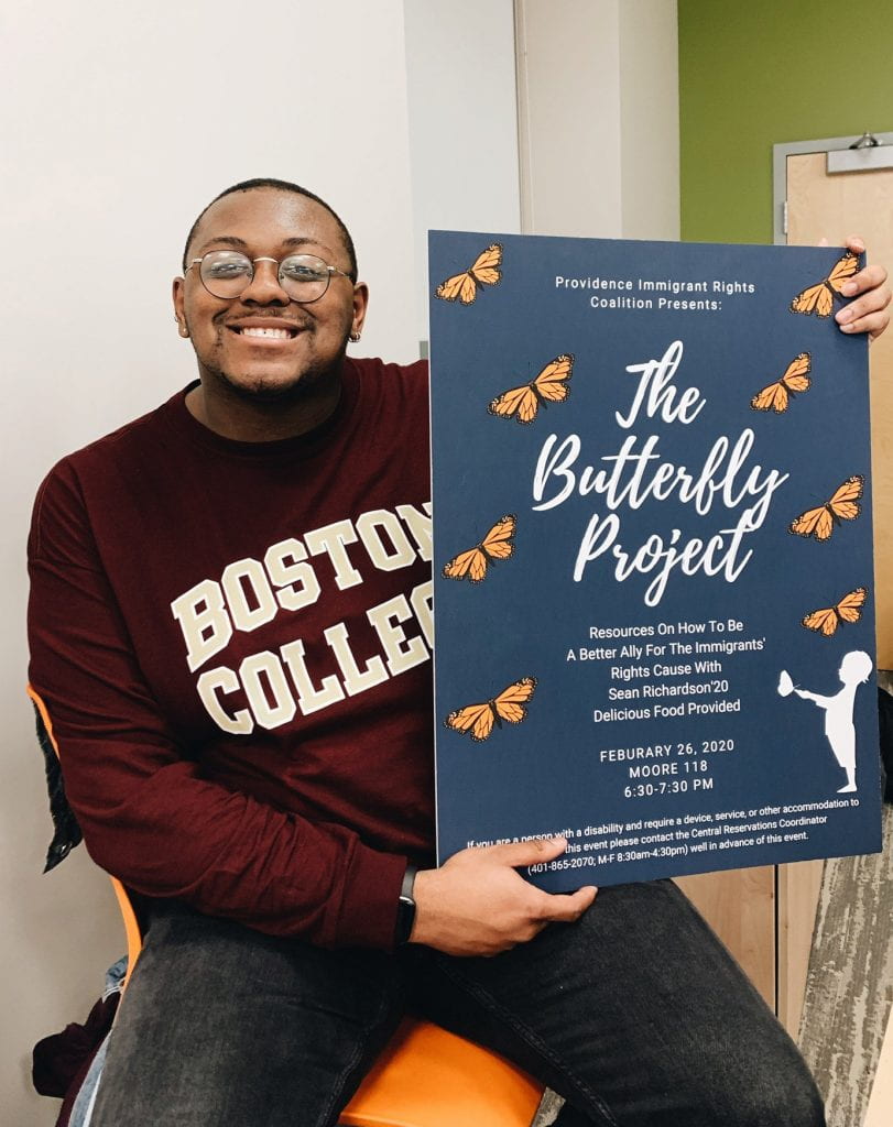 Sean Richardson '20 holds a poster for "The Butterfly Project," an event related to his independent study research.