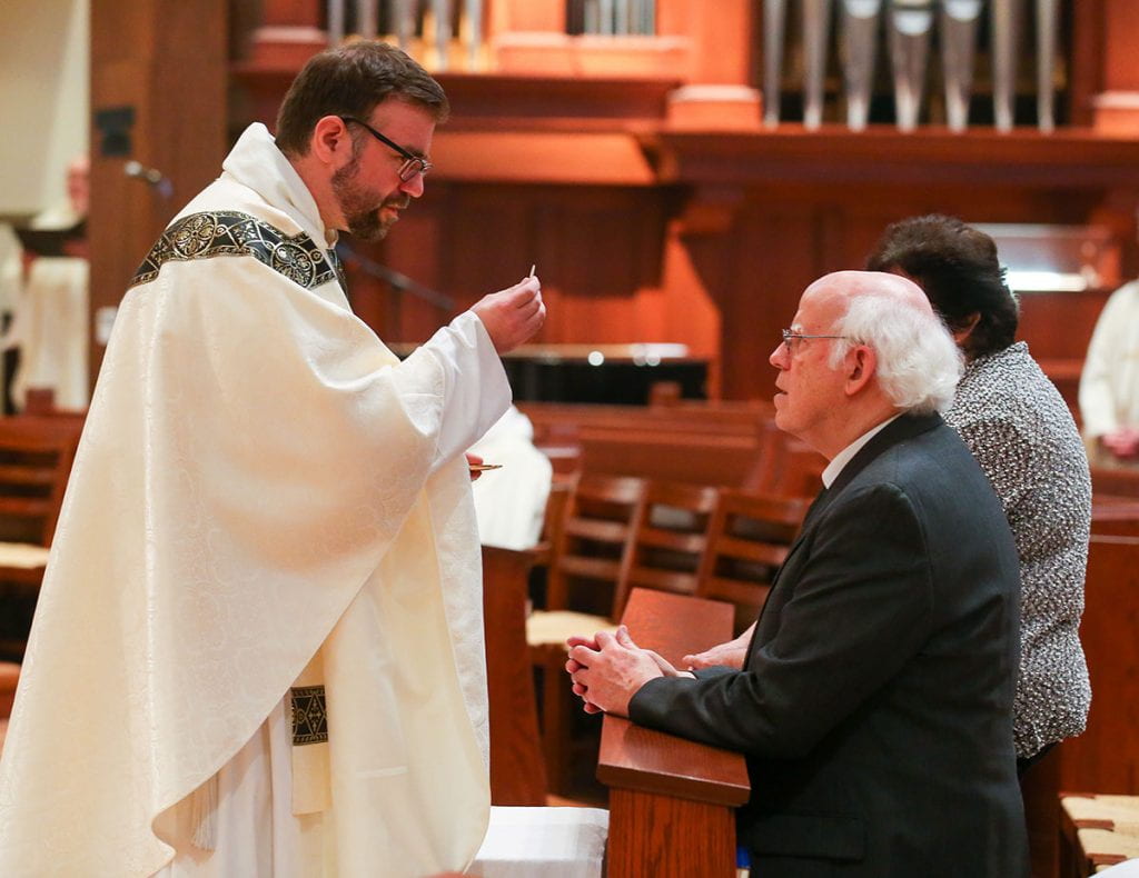 In his first act as a priest, Rev. Jordan Zajac, O.P. '04 offers the Eucharist to his parents, Peter and Judith Zajac.