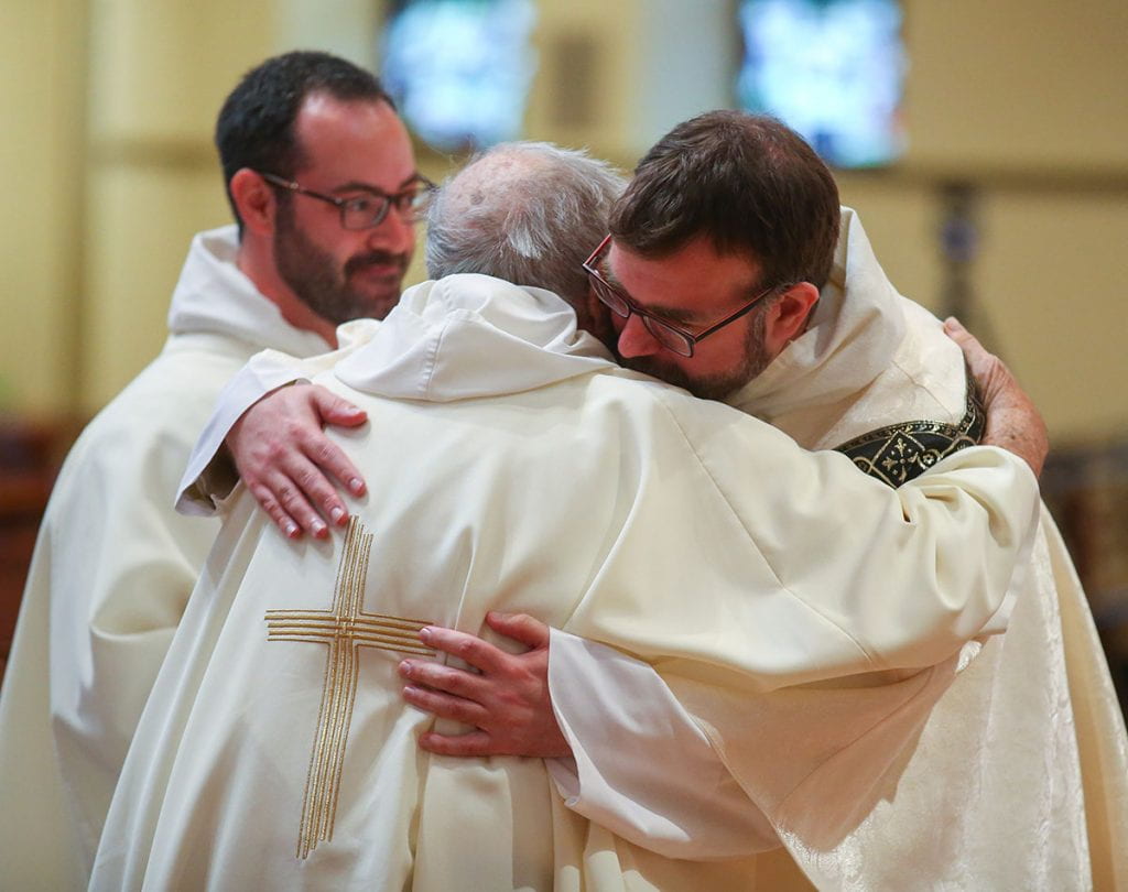 After being dressed in stole and chasuble for the first time, Rev. Jordan Zajac, O.P. '04 hugs his former theology professor, Rev. John Reid. Also pictured is Rev. Michael Weibley, O.P., assistant chaplain, who assisted.