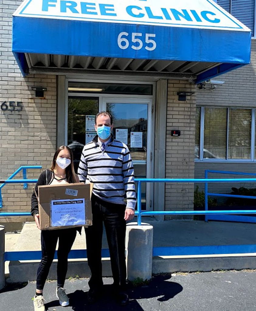 Valerie Antonio Cardozo ’21, left, drops off masks to a representative of the Rhode Island Free Clinic, which provides health care and wellness services to the needy.