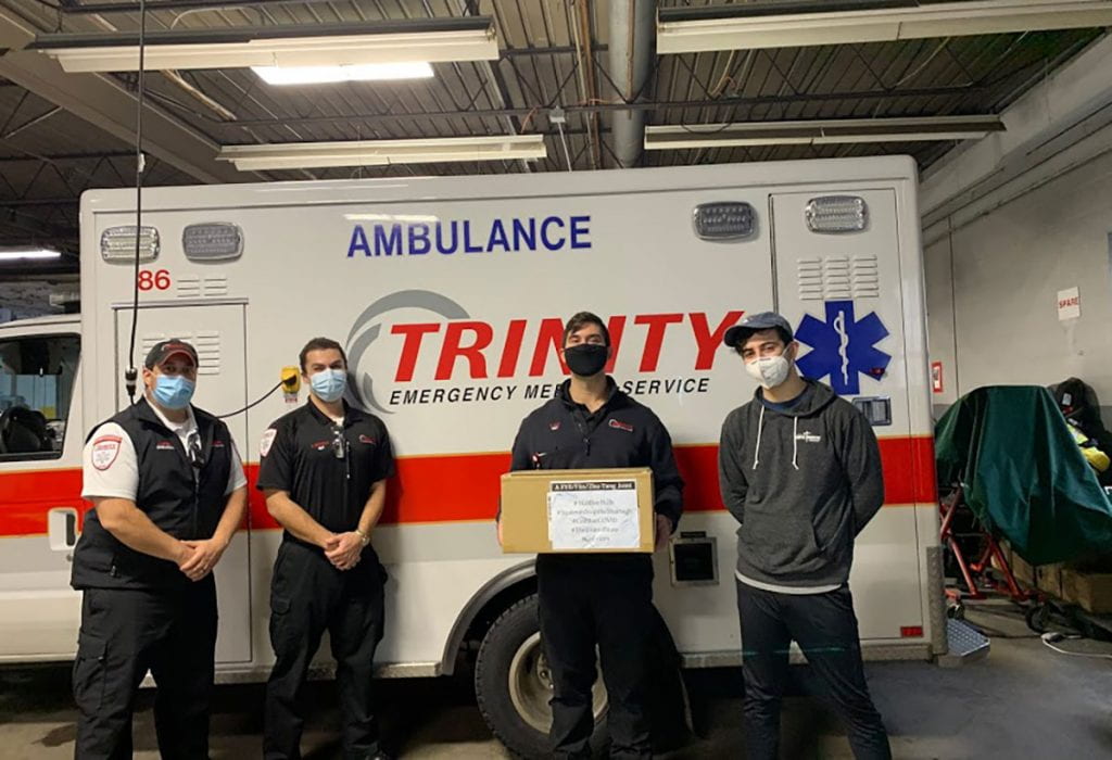 Nathan Perez ’20, right, meets EMTs with Trinity EMS in Lawrence, Mass.
