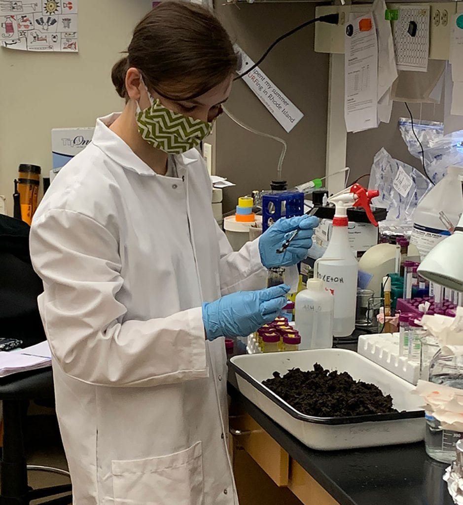Katelyn Hino ’21 packs a conical tube with mud during her research.