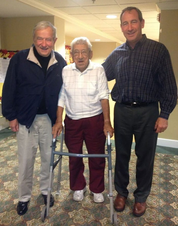 Mr. Corsini, left, and his son, Bryan M. Corsini ’83, visited Gustave C. Coté ’62Hon. in Cumberland, R.I., in 2014.