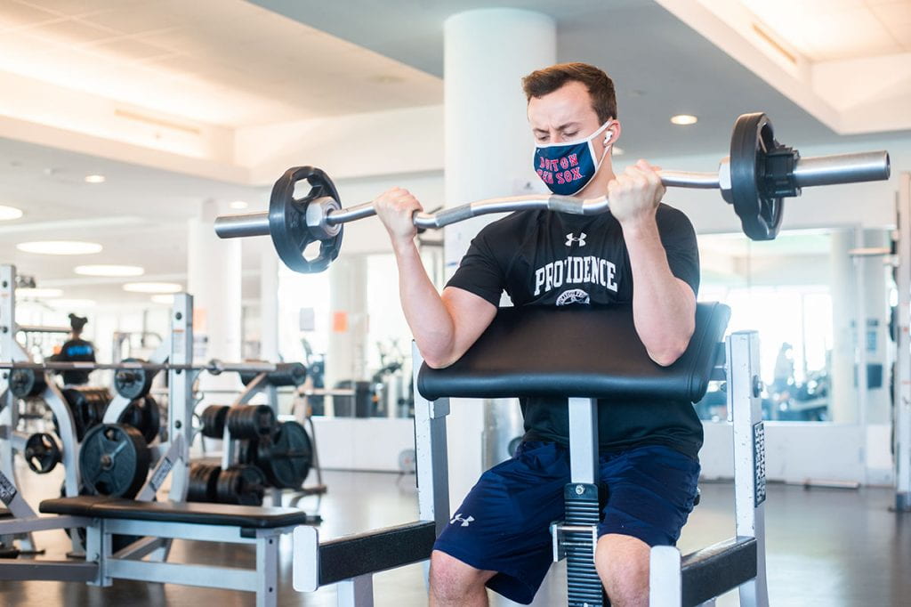 Kyle Thompson '22 says workouts in Concannon Fitness Center helped him cope with the stresses of the semester. He is lifting weights.