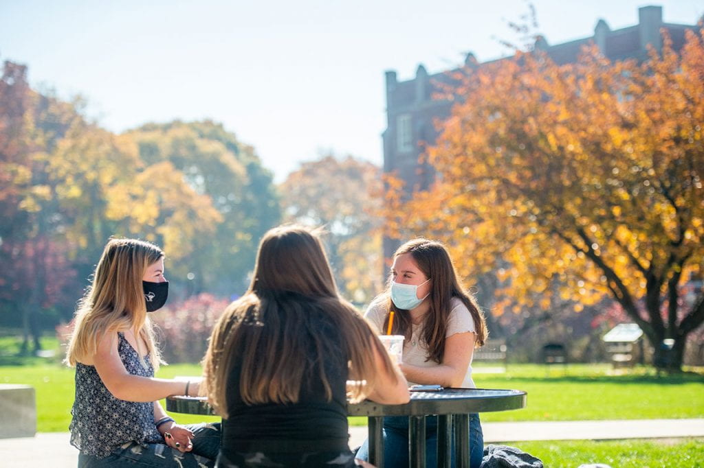 Emily Reynolds '23, left, shares a table outside Slavin Center with friends, including Daisy Donovan '23.