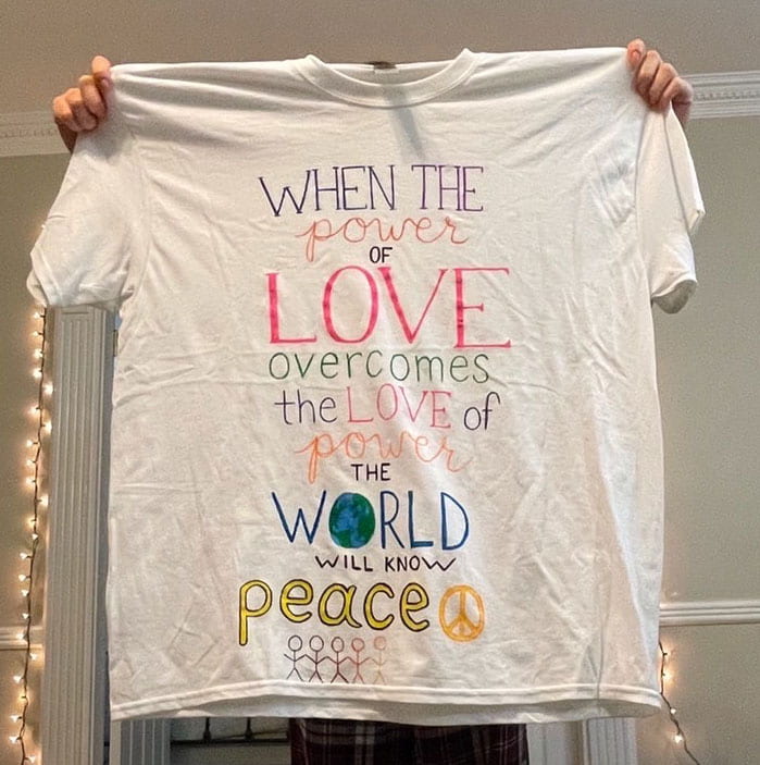 "When the power of love overcomes the love of power, the world will know peace," this T-shirt reads.