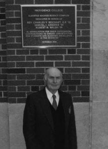 Robert H. Walsh '39 & '66Hon. stands under the plaque at Albertus Magnus Hall that acknowledges the building's dedication to him.