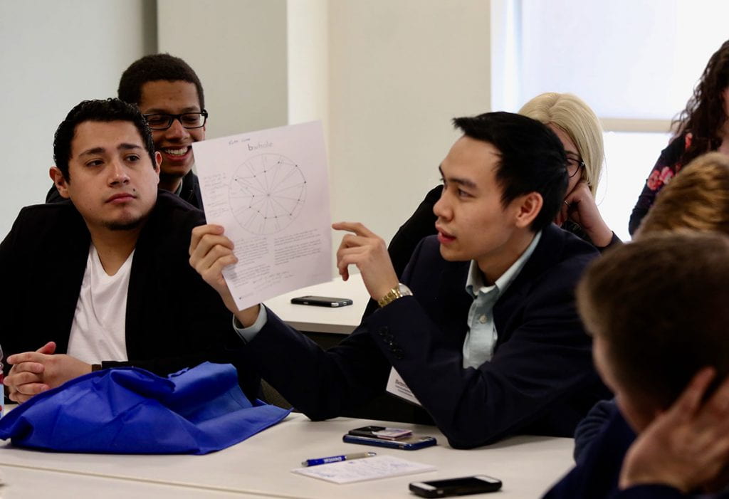 Benedict Portugal ’20 holds a paper while responding to College Leadership Rhode Island classmates during a group session.