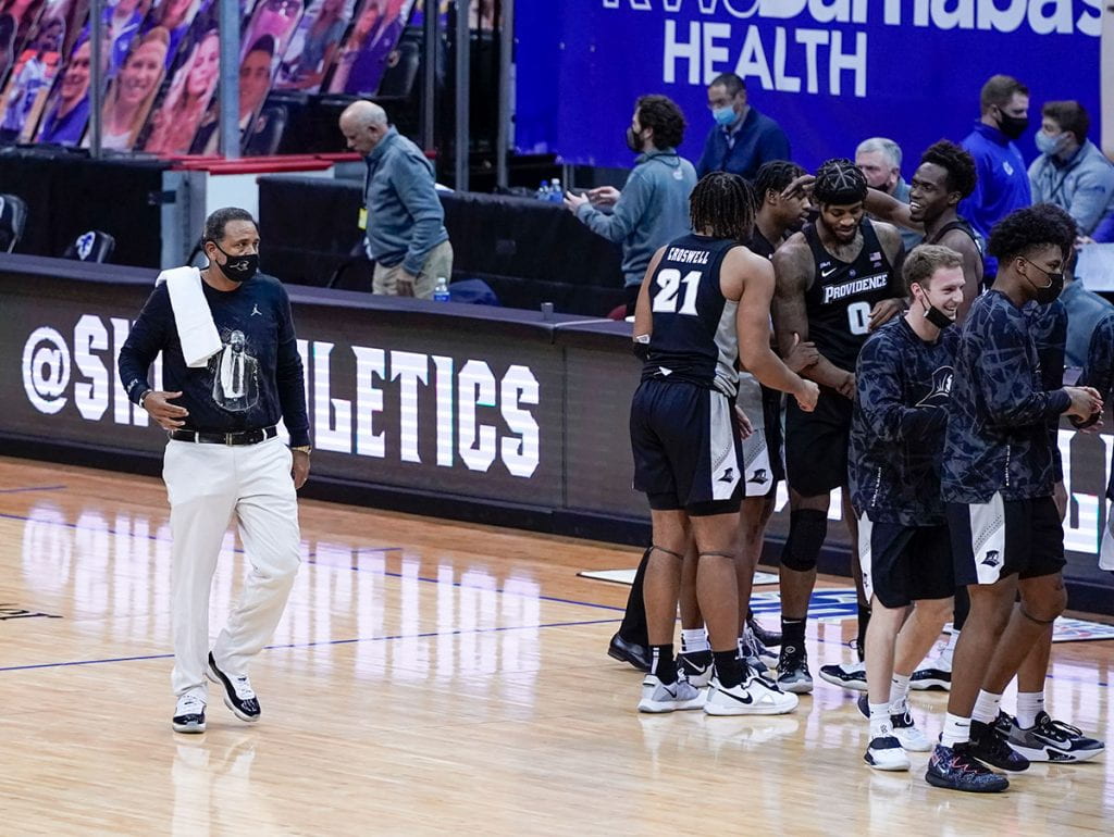 Coach Ed Cooley wears a towel and a shirt in honor of the late John Thompson Jr. ’64 during the Friars’ game at Seton Hall this past season.