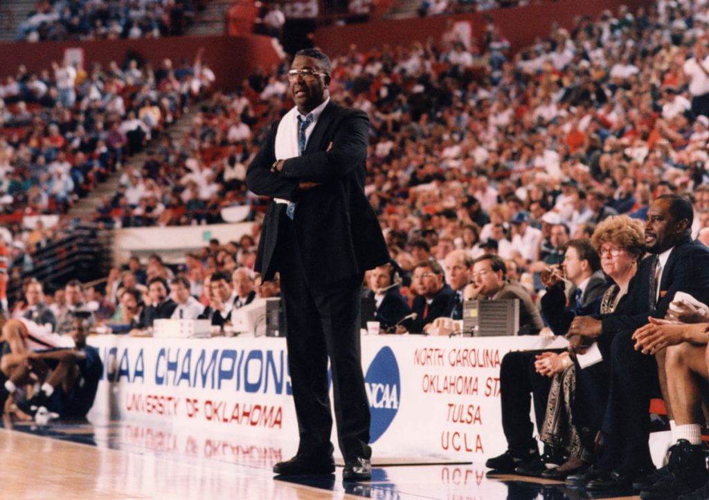 John Thompson Jr. ’64, with the trademark towel hung over his shoulder, coaches his Georgetown Hoyas in an NCAA Tournament game.