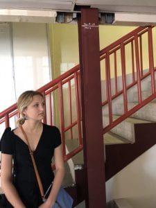 Madeleine Weil ’19 visits a community service agency in the northwest of Puerto Rico in December 2018. The mark on the pillar next to her shows how high the floodwaters from Hurricane Maria reached in 2017.