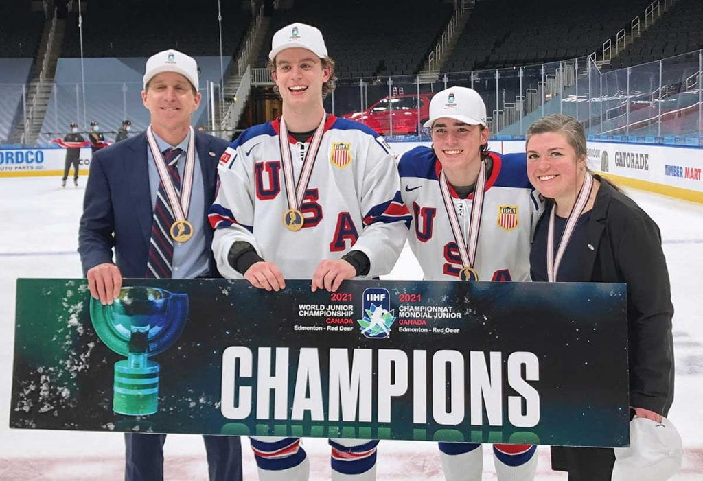 From left, U.S. National Team head coach Nate Leaman, Patrick Moynihan ’23, Brett Berard ’24, and video coach Theresa Feaster ’14, ’16G gather for a celebratory photo after the gold medal.