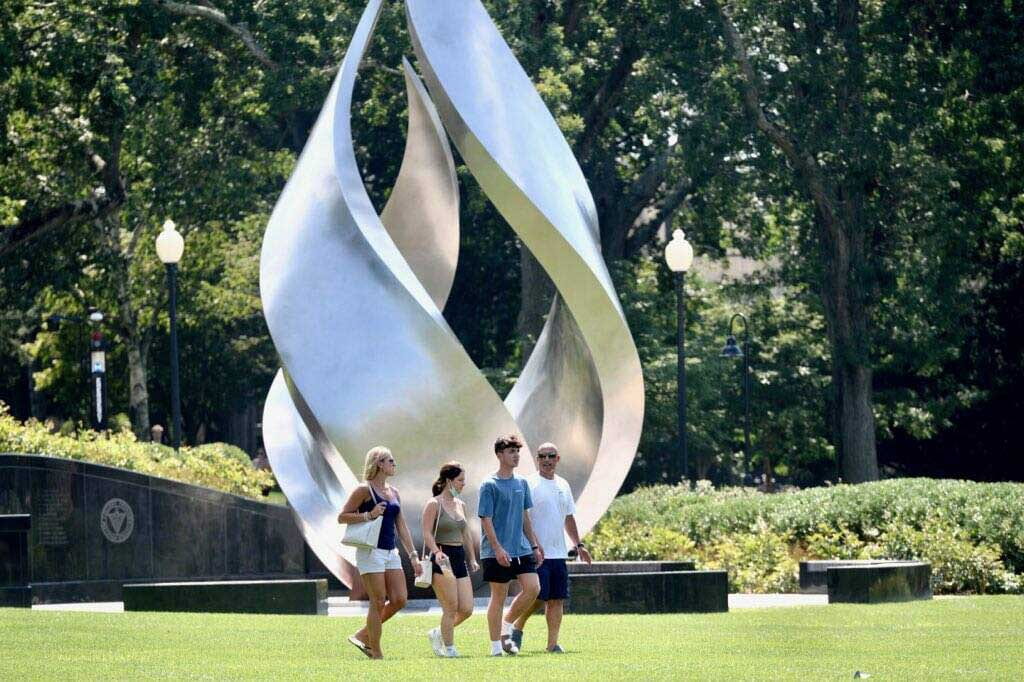 A family crosses campus near Calabria Plaza on Move-In Day for students in the Class of 2025.