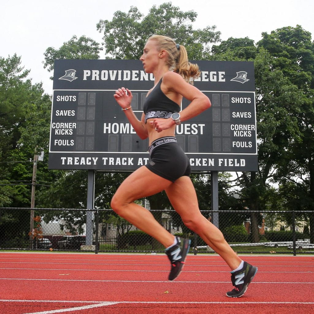 Emily Sisson '14 runs on the Ray Treacy Track in July, with the Providence College scoreboard behind her.