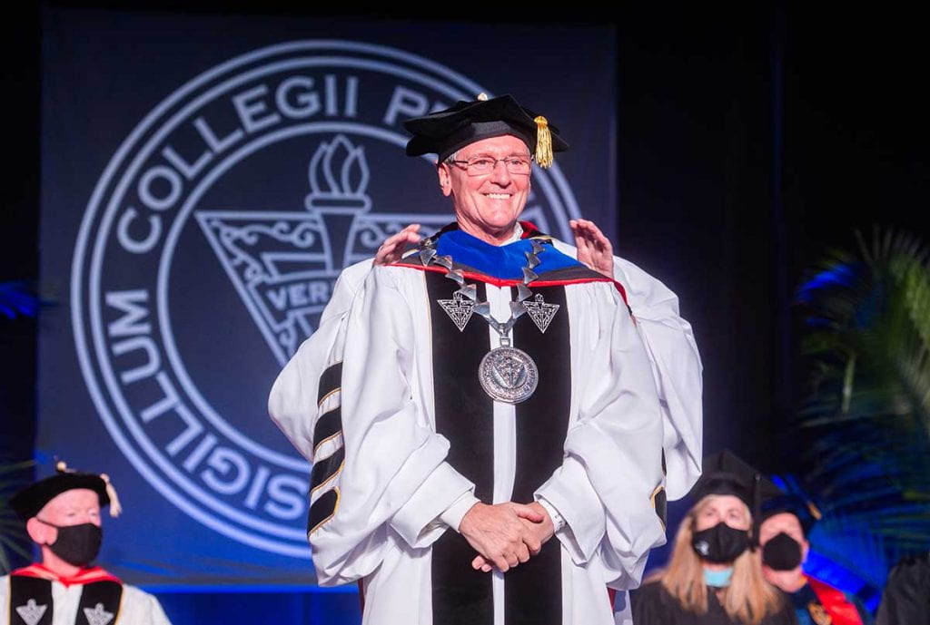 Rev. Kenneth R. Sicard, O.P. '78, '82 smiles as he receives the medallion, the traditional symbol of the office of the president, from Very Rev. Kenneth Letoile, O.P. '70, prior provincial of the Dominican Province of St. Joseph.